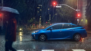 Toyota Prius in the rain, under stop light