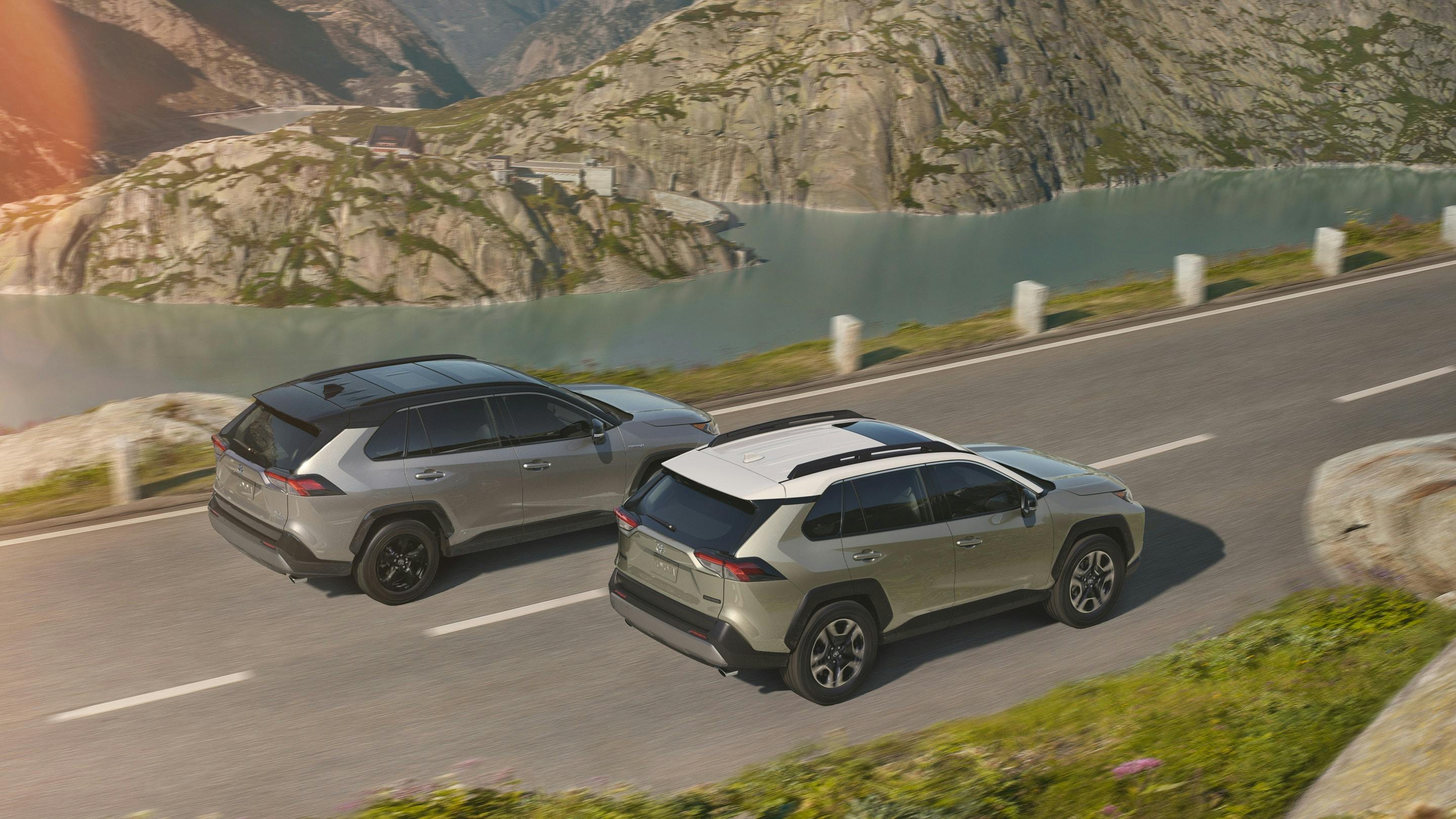 two toyota RAV4s with lake/mountainous background