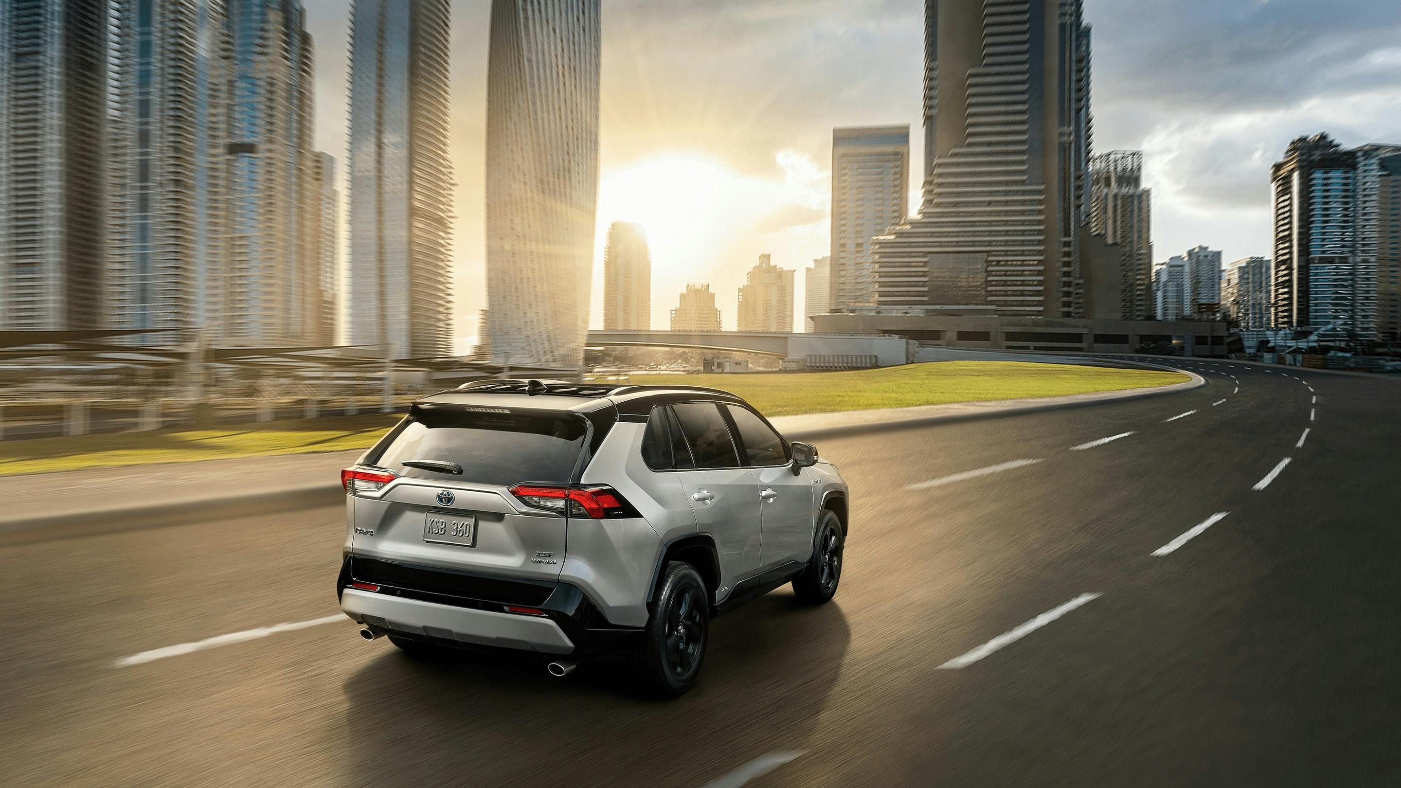 silver toyota RAV4 with modern city background