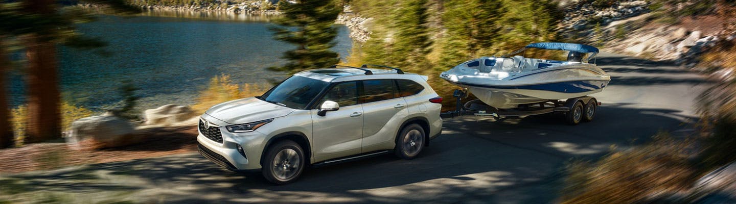 2021 Toyota Highlander Towing a Boat on the Road