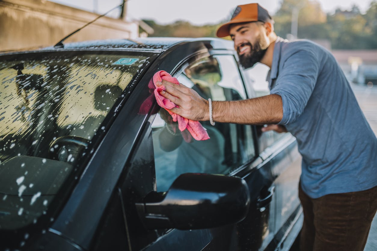 Handsome man washing car