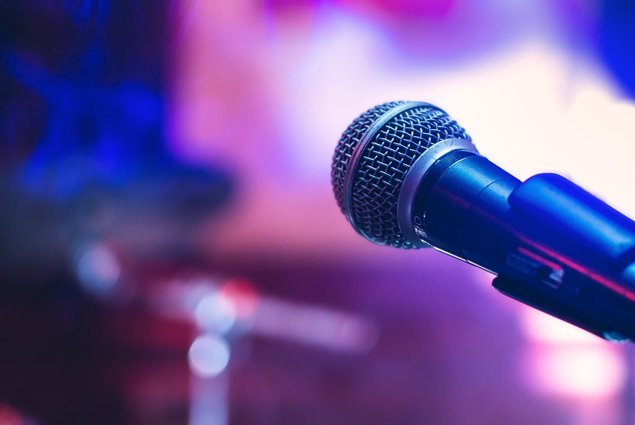 Microphone on the stage on violet background.