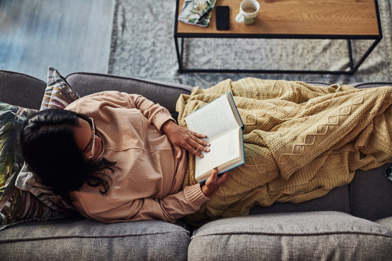 young woman reading a book on the sofa