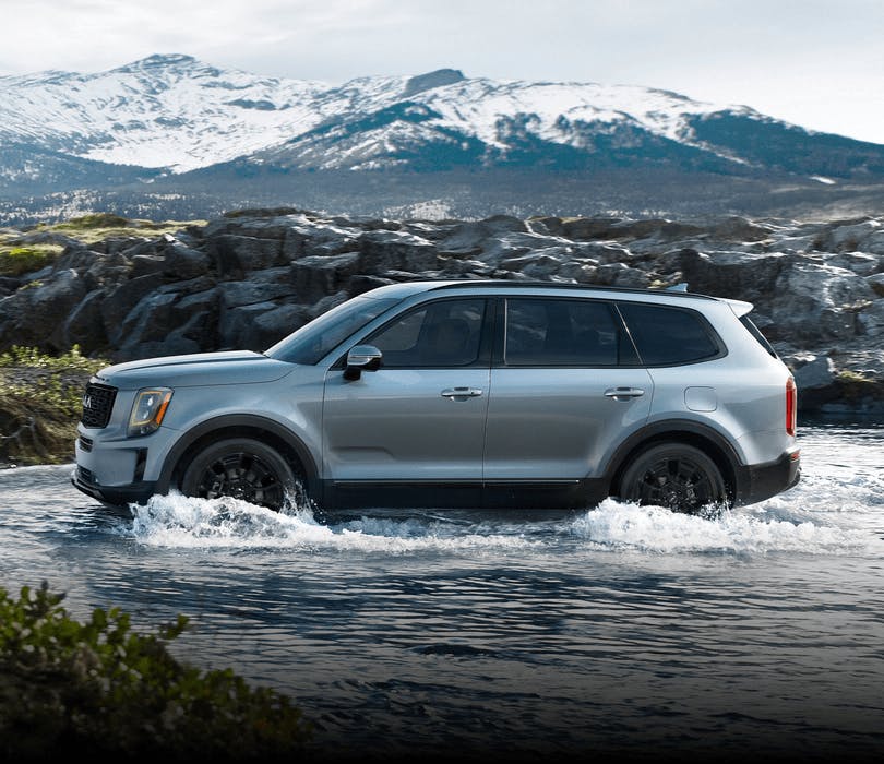 blue kia telluride driving through water