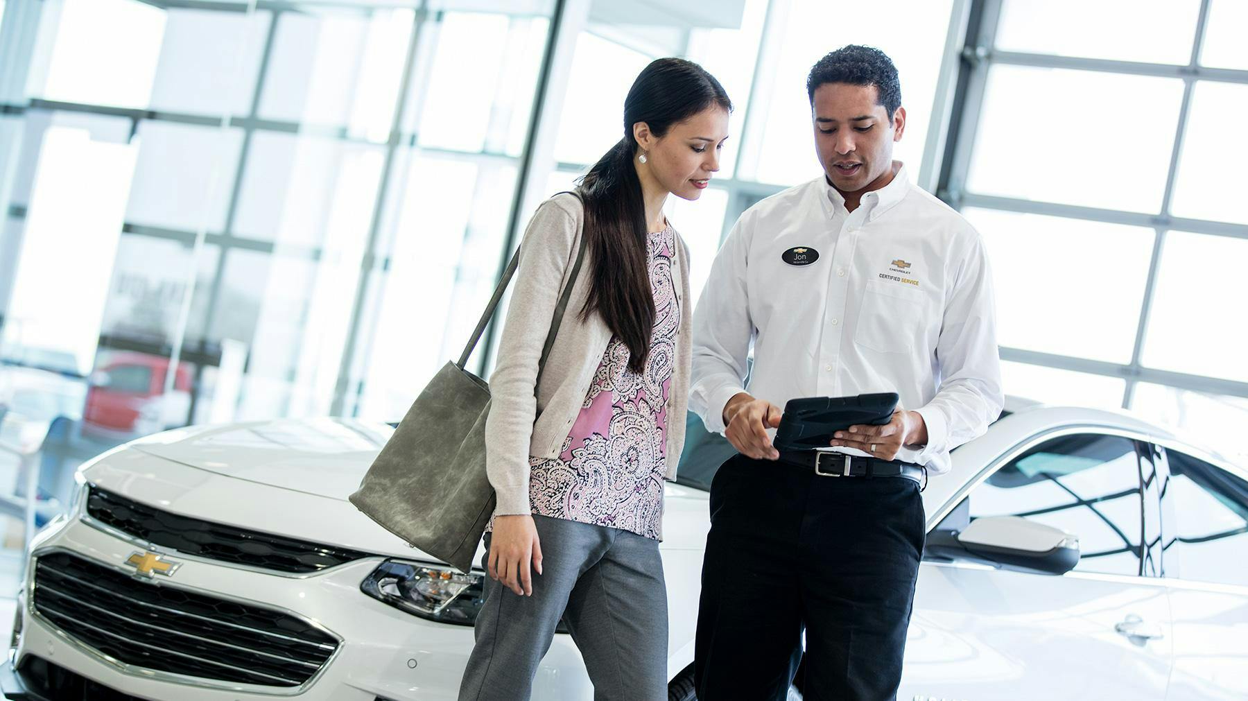 OWNER BENEFITS Man and women looking at Smartpad in showroom