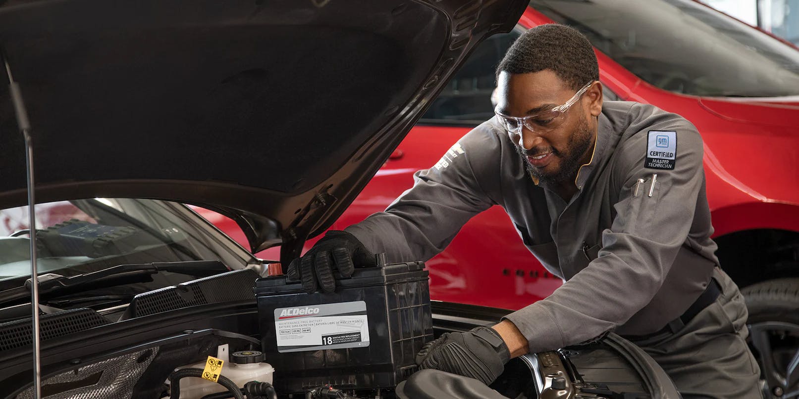 male technician replacing chevy battery