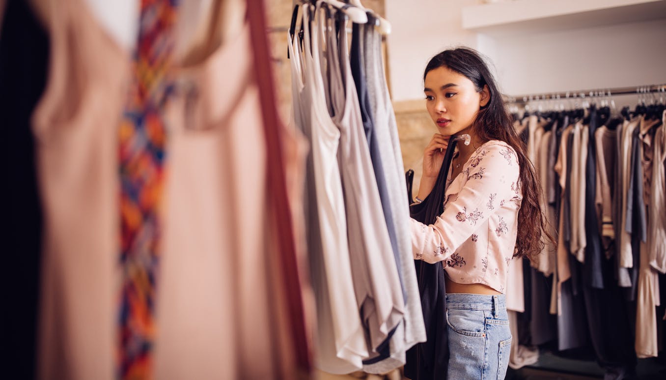 woman browsing and looking to buy summer clothes in a boutique