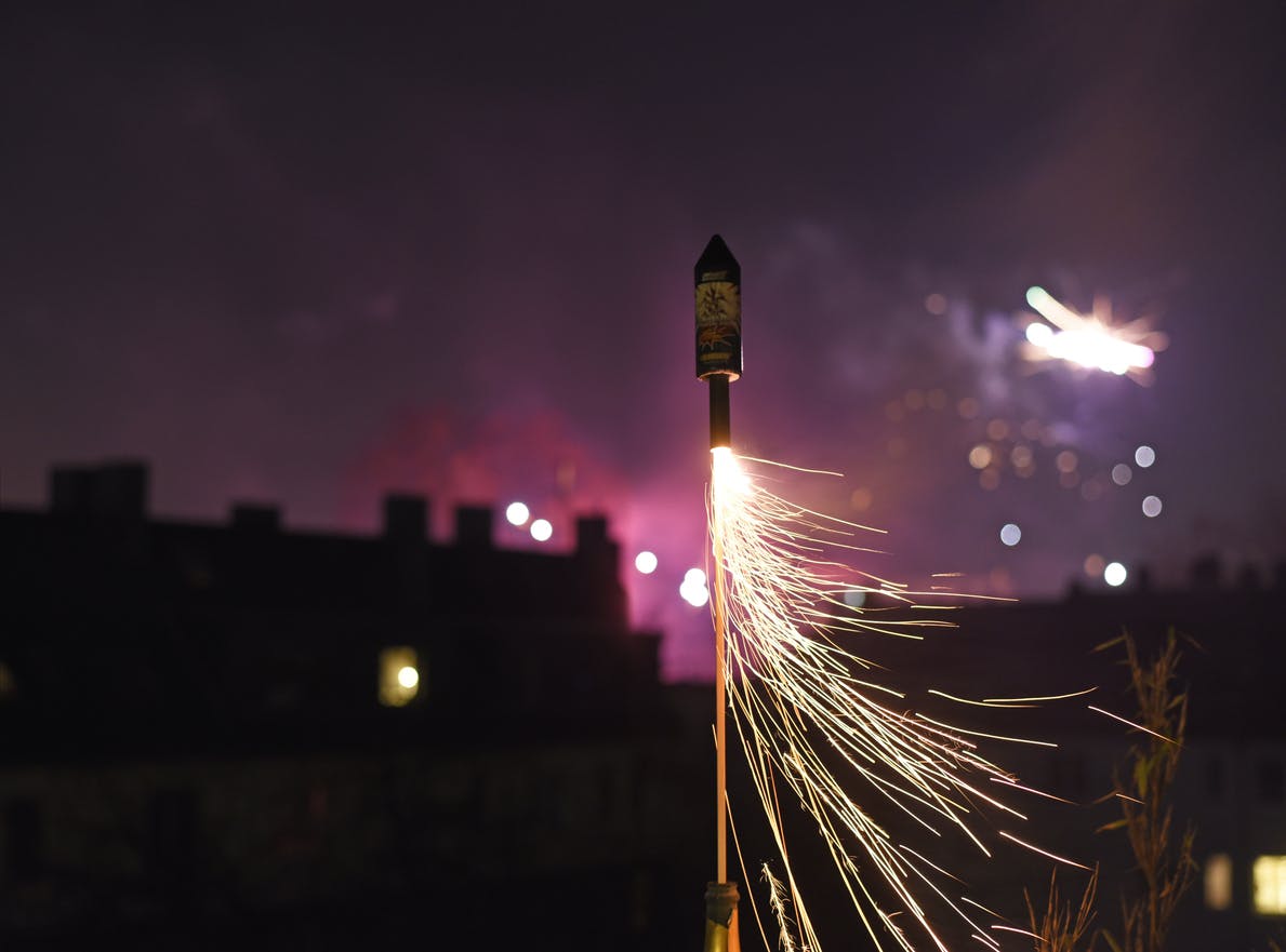 a bottle rocket spraying sparks at night