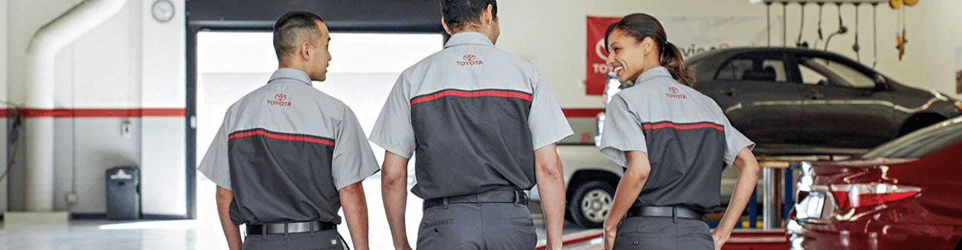 Three Toyota service technicians walking through garage