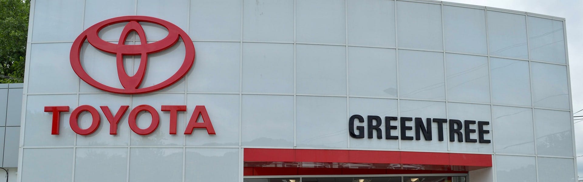 toyota logo next to greentree logo on building