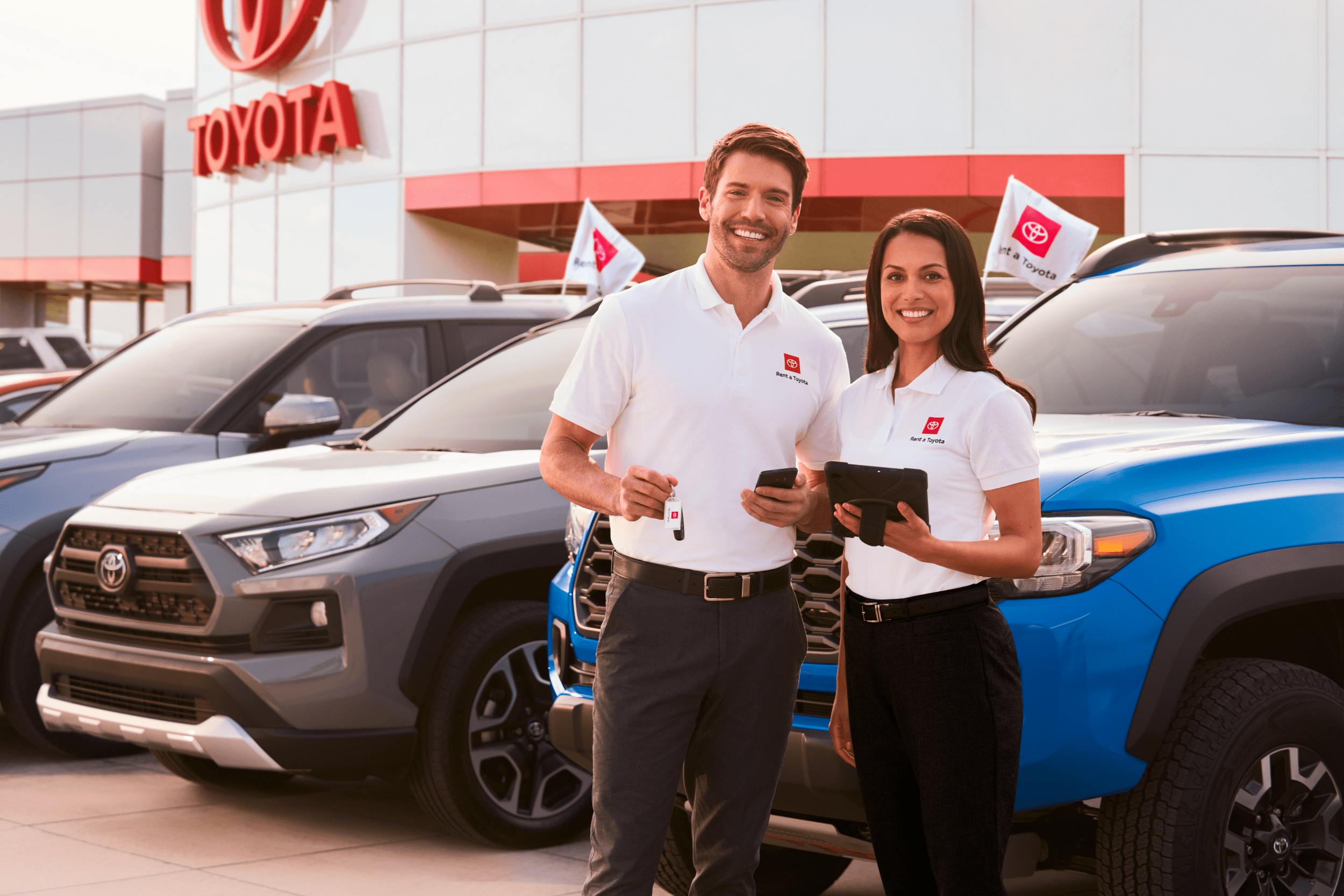 man and woman standing in front of row of cars