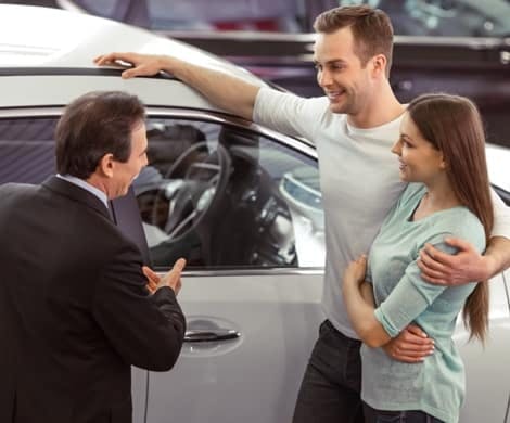 Car-Salesman-Speaking-with-Couple