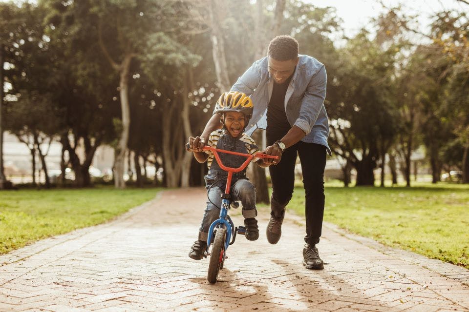 Father teaching his son bicycling at park