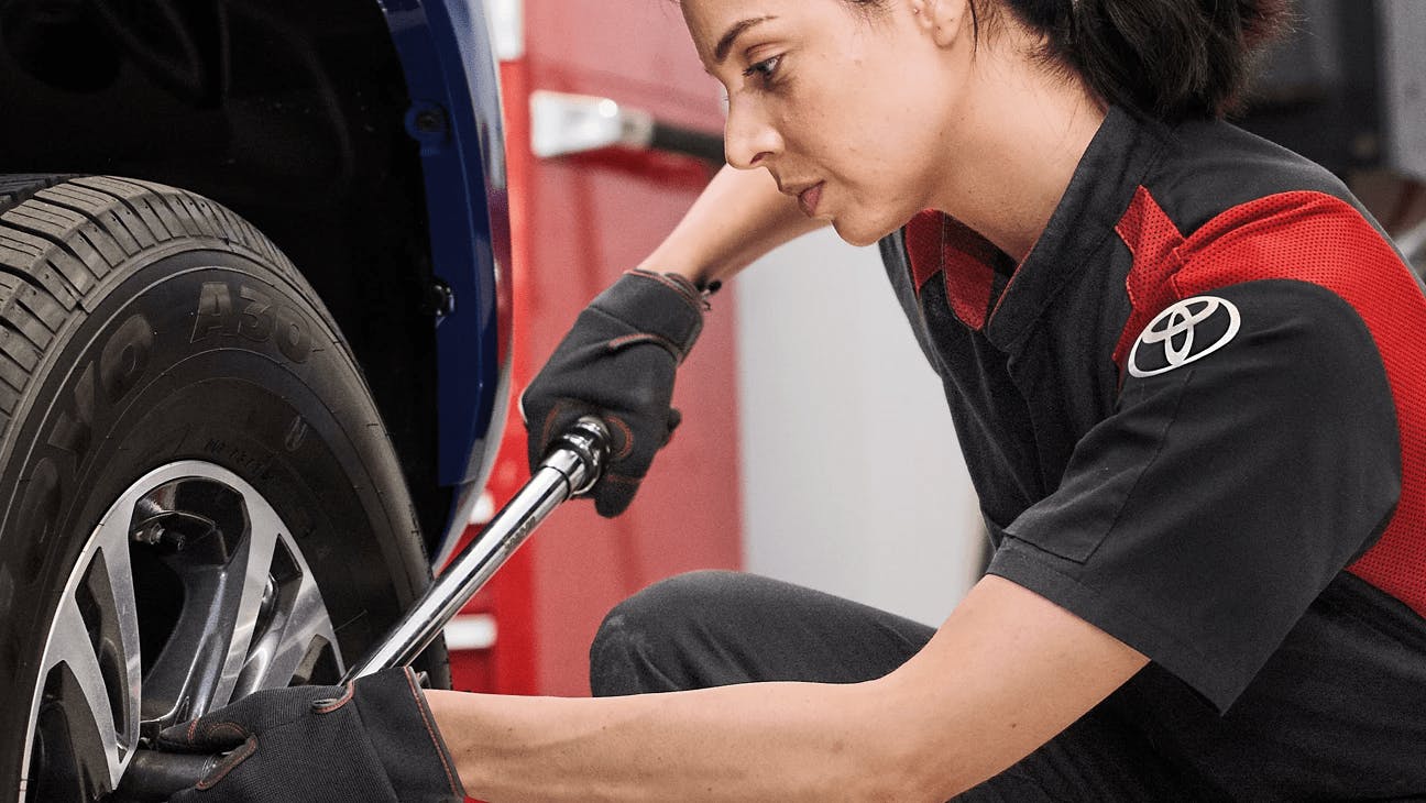 female technician working on vehicle wheel