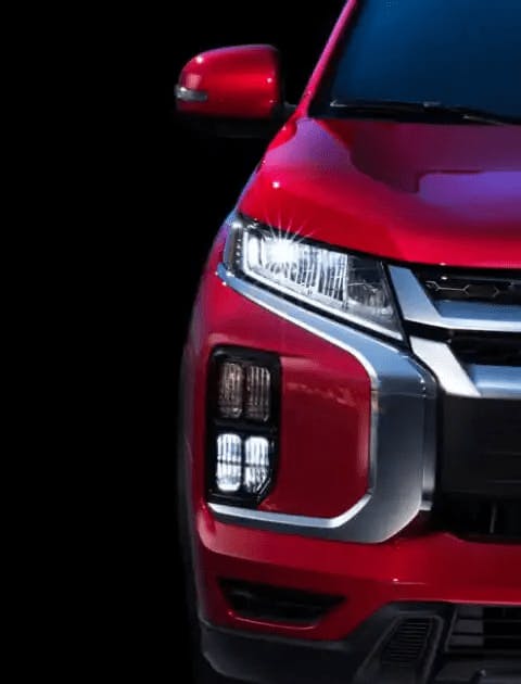 close up view of headlights on red 2022-mitsubishi-outlander-sport