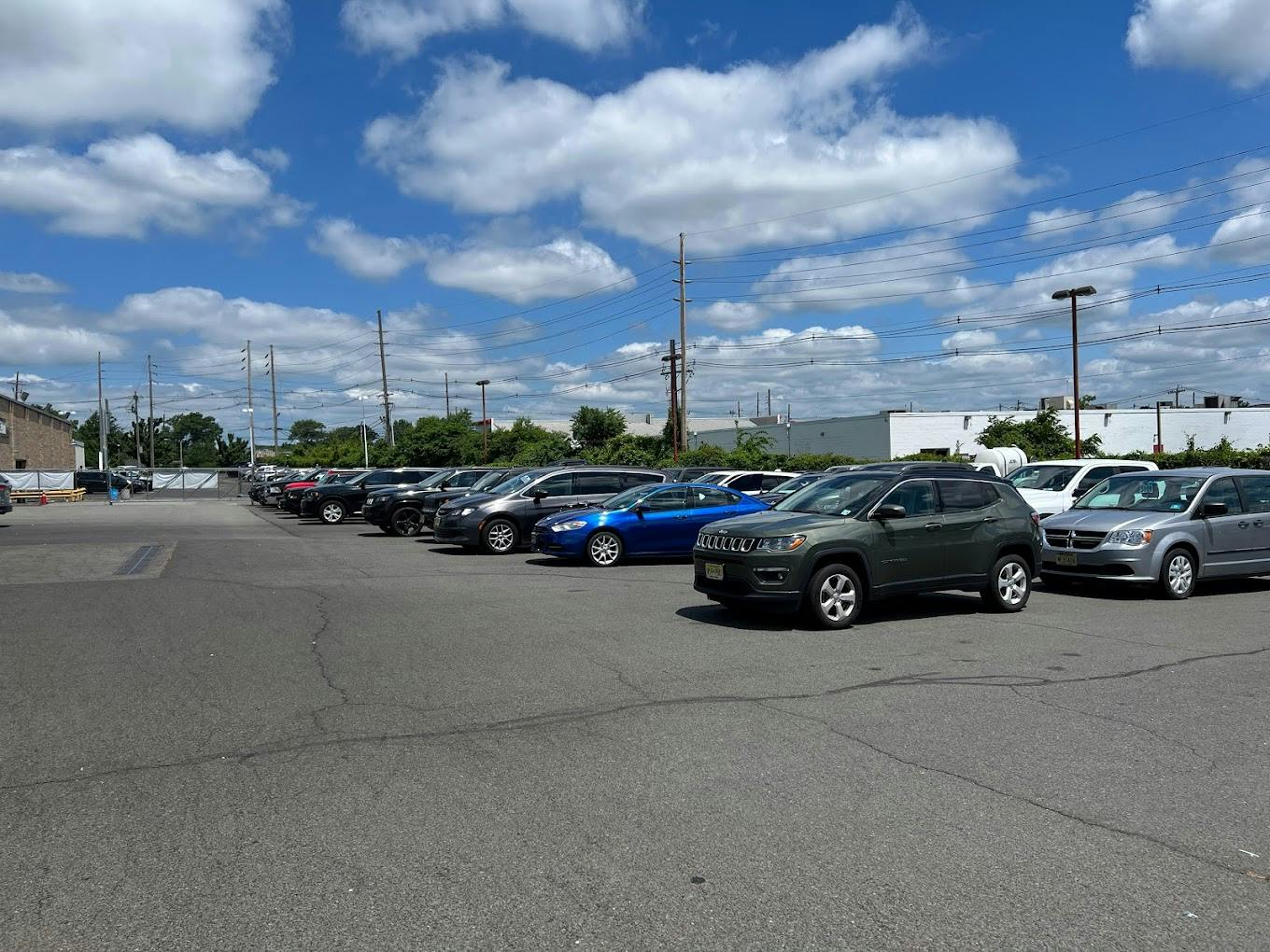 vehicle car lot with blue sky and white clouds