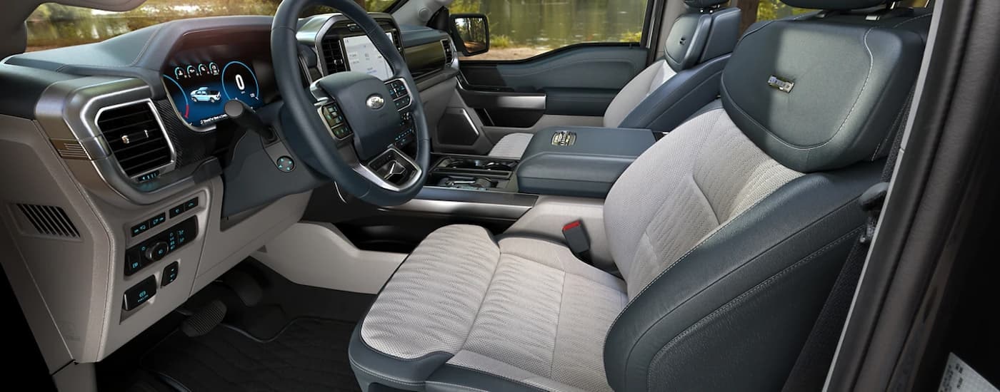 The black and grey interior of a 2023 Ford F-150 Limited shows the front seating and console.