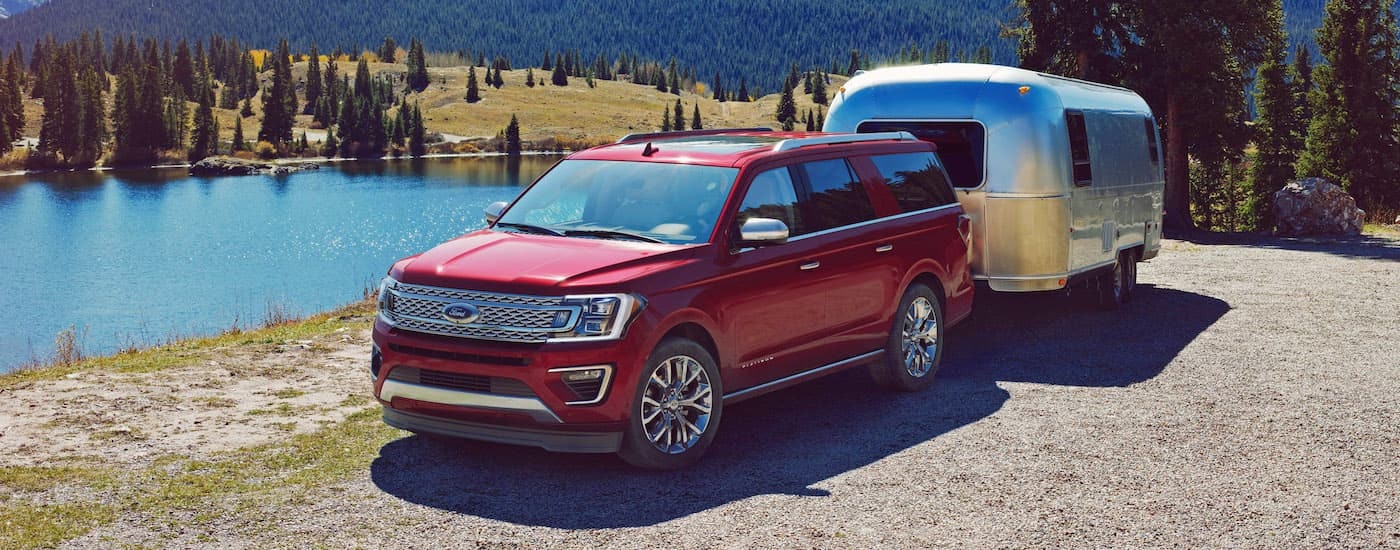 A red 2018 Ford Expedition is shown towing an airstream near a lake after leaving a Ford dealer near Brattleboro, VT.