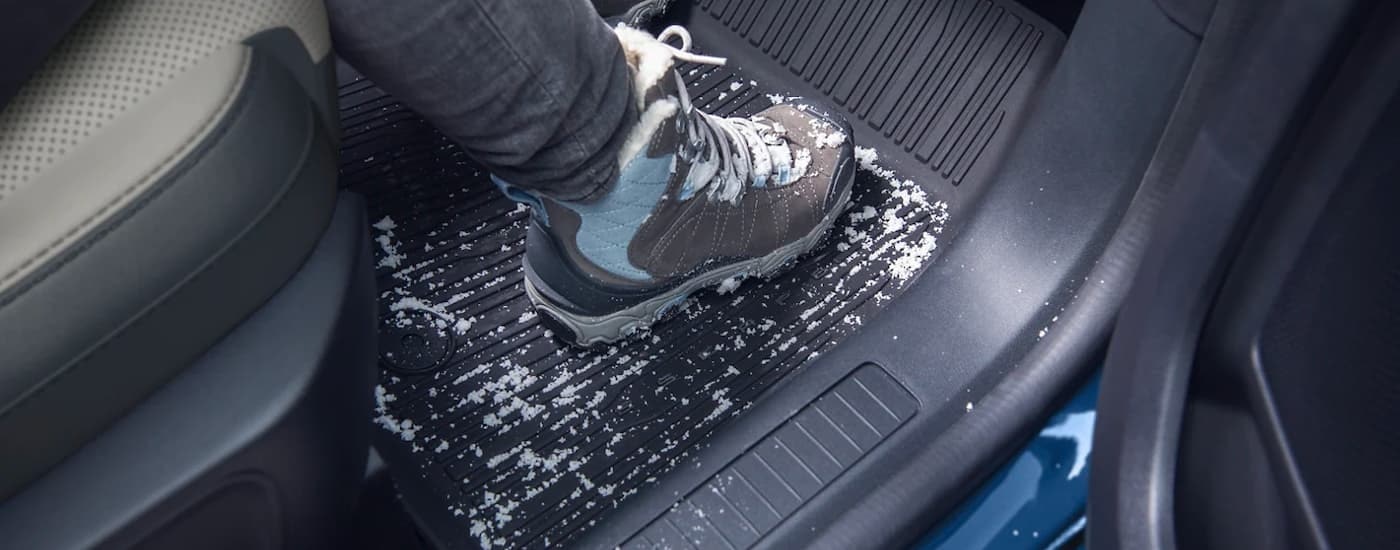 A close up shows snowy boots on the floor mat in a 2023 Ford Escape.