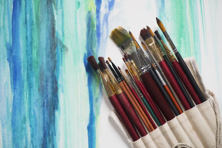 Paintbrushes over the watercolor painting.