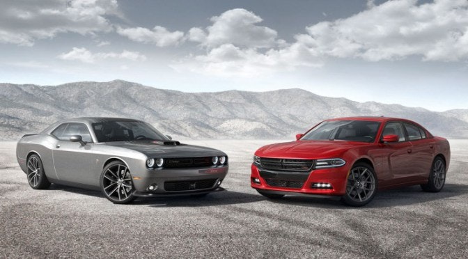 Charger and Challenger parked next each other in a gravel field