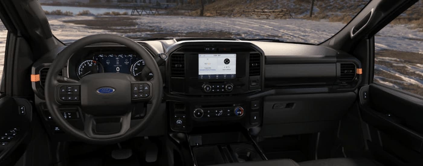 A close up of the steering wheel and center console of a 2022 Ford F-150 Tremor for sale near Keene, NH is shown.