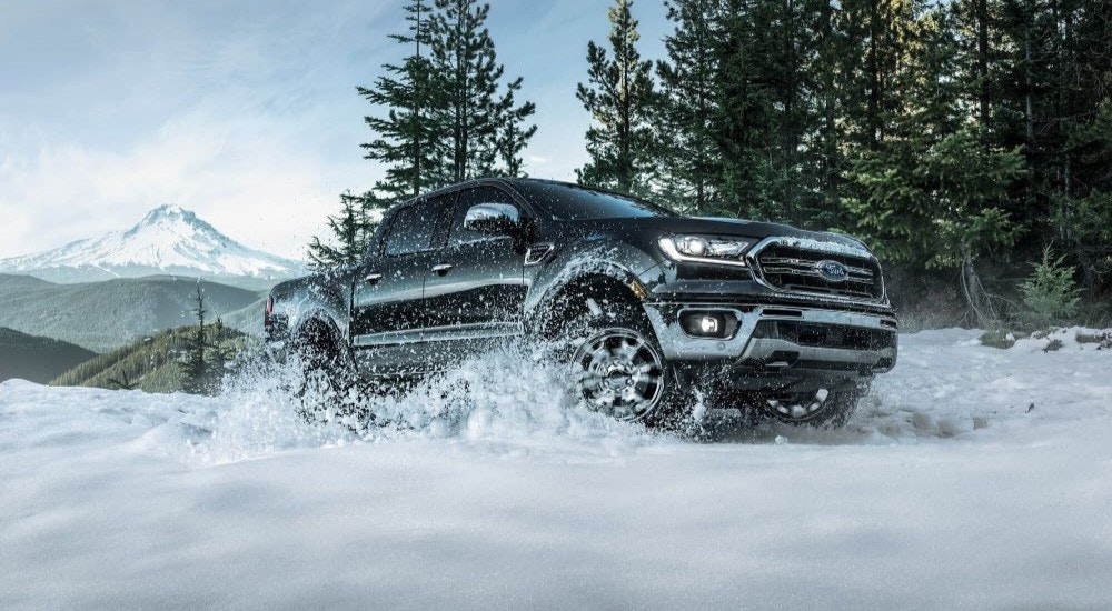 A black 2021 Ford Ranger FX4 is shown kicking up snow.