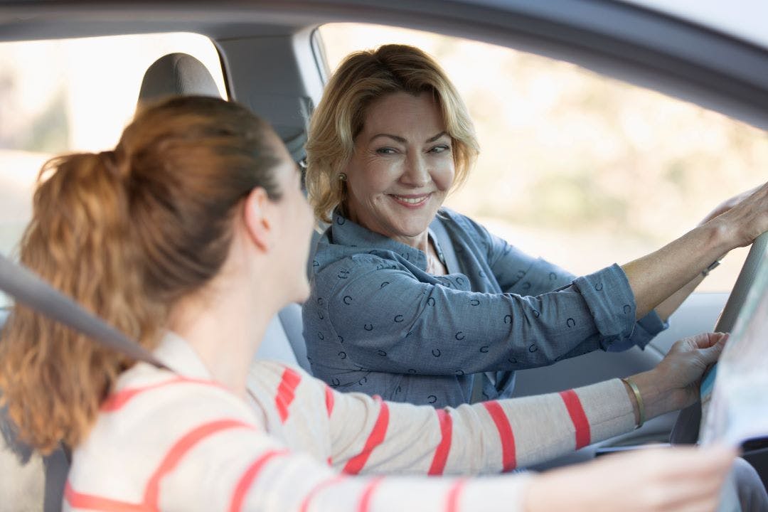 a mom looking at daughter in the car