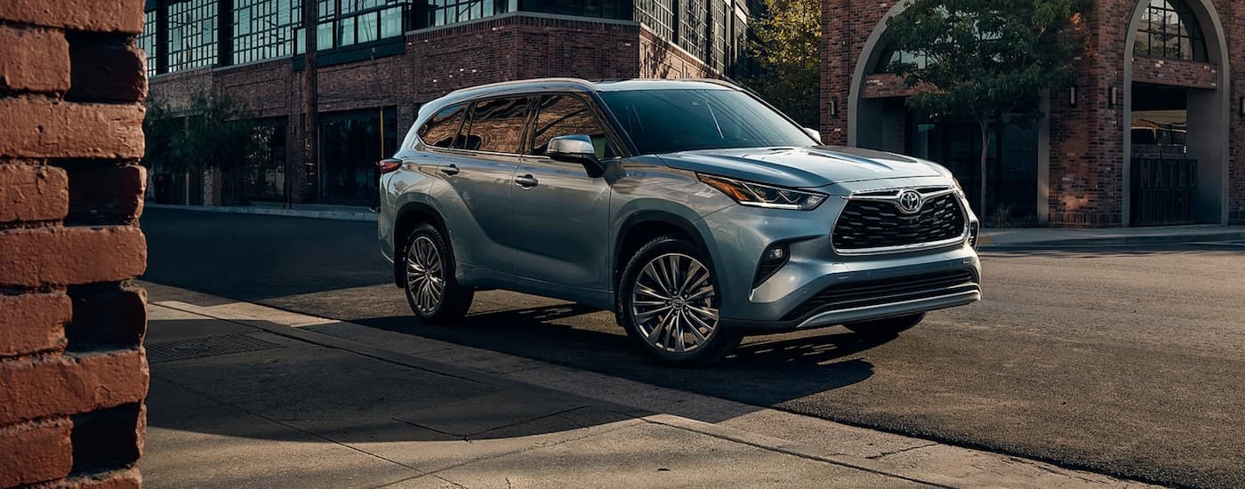 A grey 2020 Toyota Highlander is shown parked on the side of a city street.