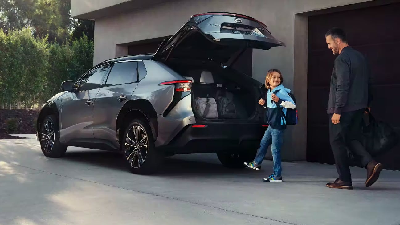 father and son loading vehicle using hands-free liftgate on Toyota bZ4X
