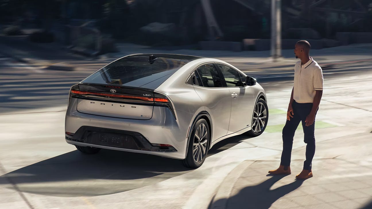 man looking at parked prius 2023 man looking at grey parked prius 2023