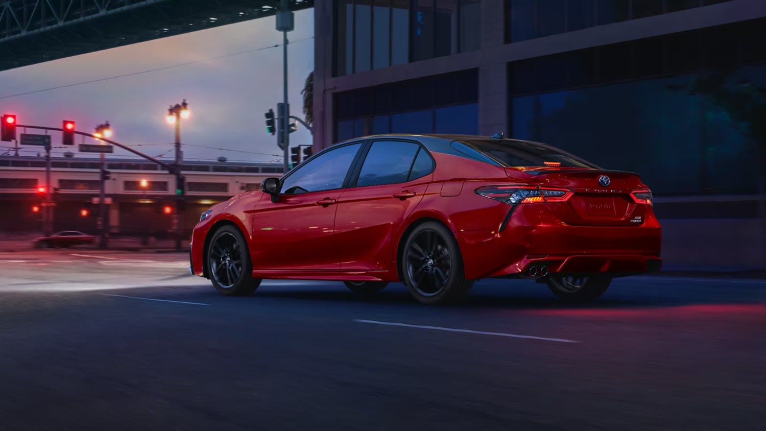 red 2023 camry side view at night
