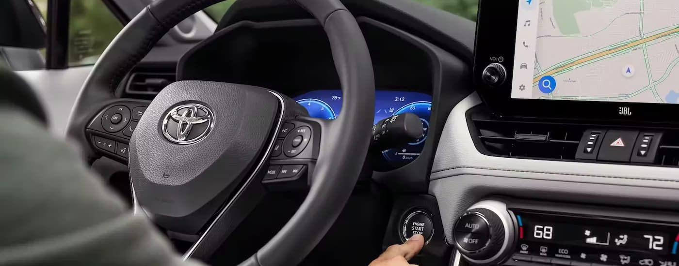 A close up of the steering wheel and infotainment screen in a 2023 Toyota RAV4 is shown.