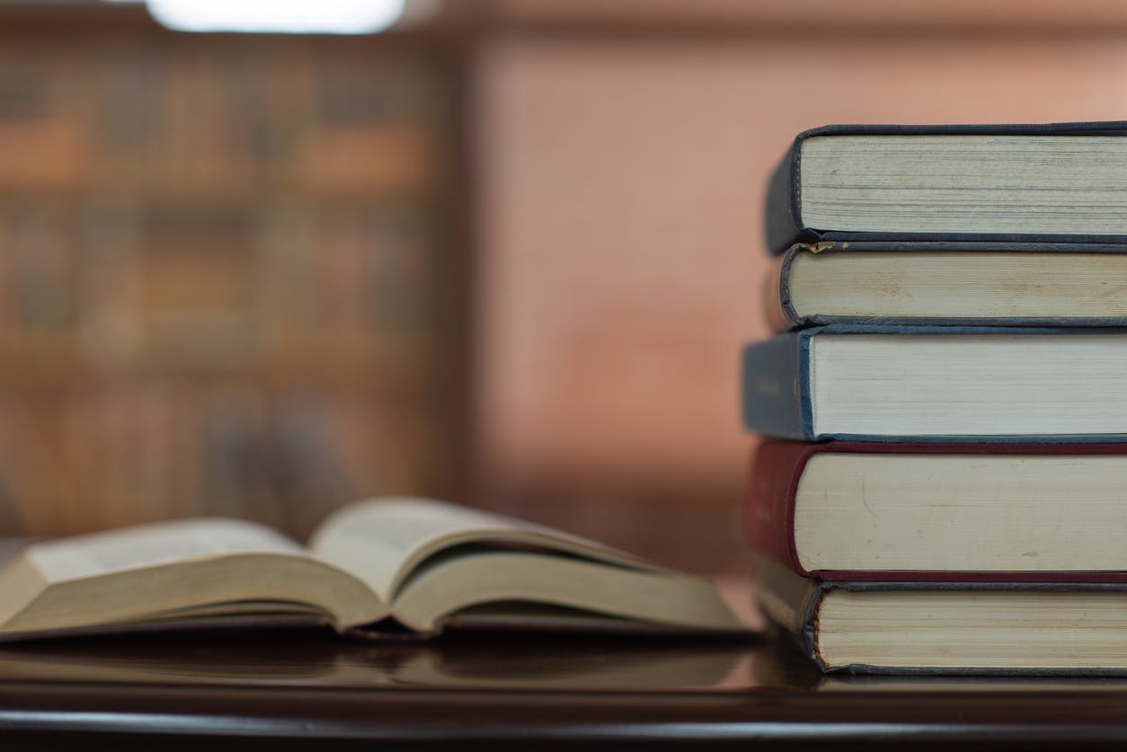 books stack and book open on desk in library