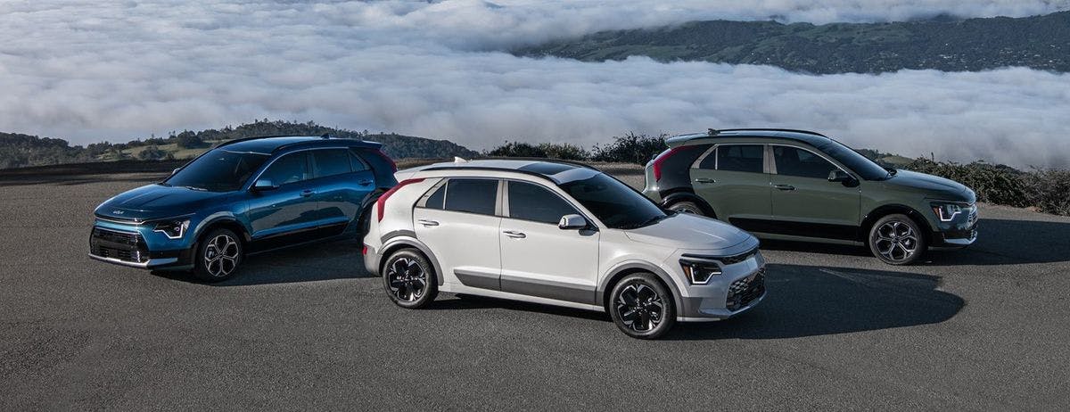 blue, white, and gray kia niro parked on a pavement