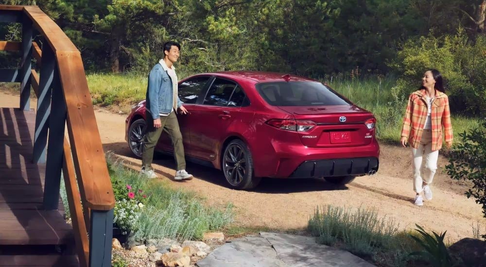 A red 2023 Toyota Corolla Hybrid SE is shown on a dirt path.