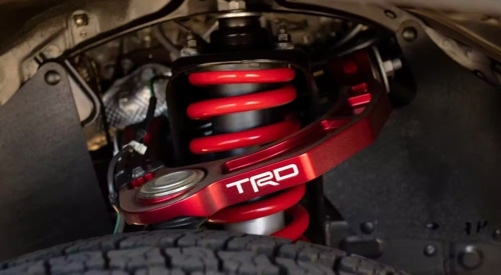 A close up shows the red suspension on a 2023 Toyota Tacoma TRD.