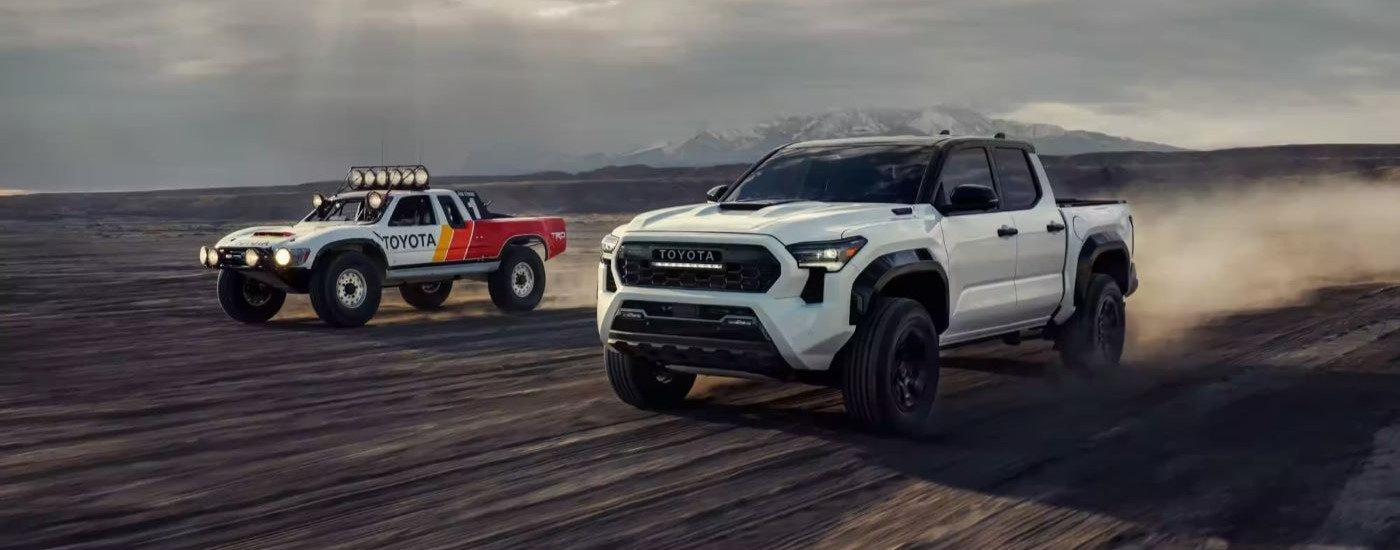 A white 2024 Toyota Tacoma TRD Pro is shown kicking up dust.