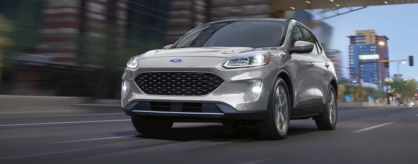 A silver 2021 Ford Escape is shown driving on a city street.