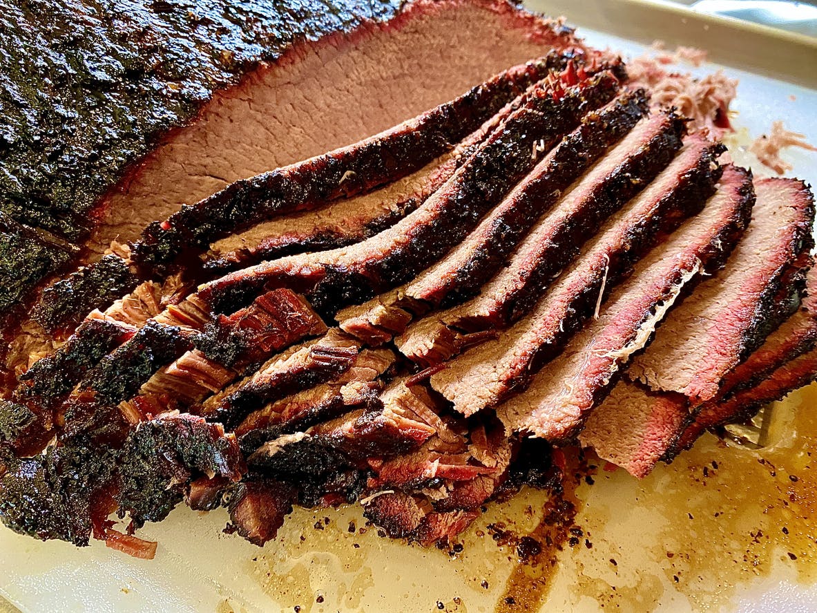 Whole beef brisket being sliced.