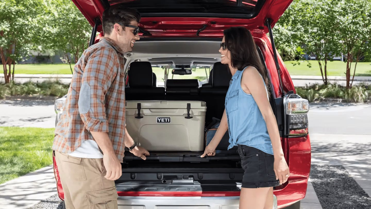 couple loading a Yeti cooler in the trunk of a 2023 4runner