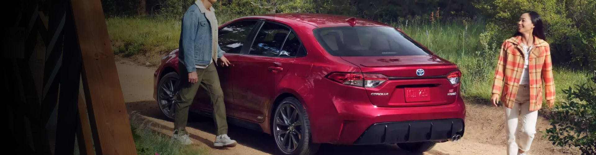 couple with red Corolla banner