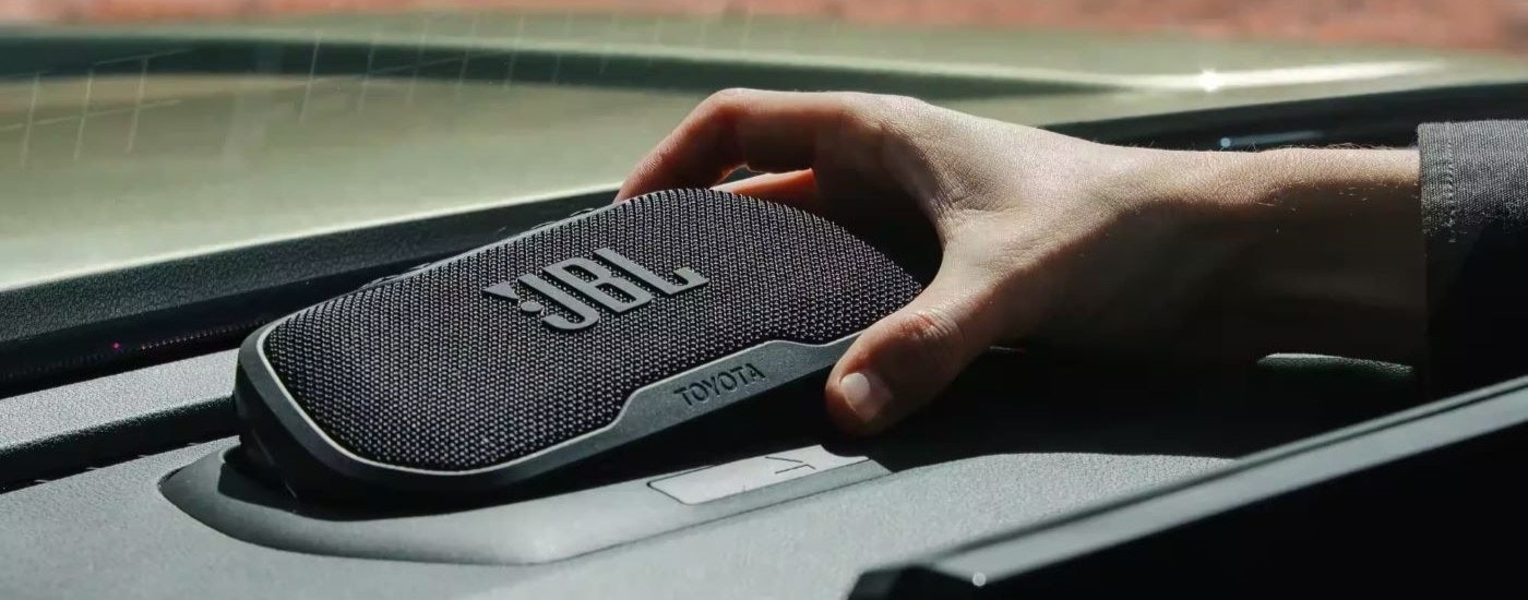 A person is shown touching a JBL speaker in a 2024 Toyota Tacoma.