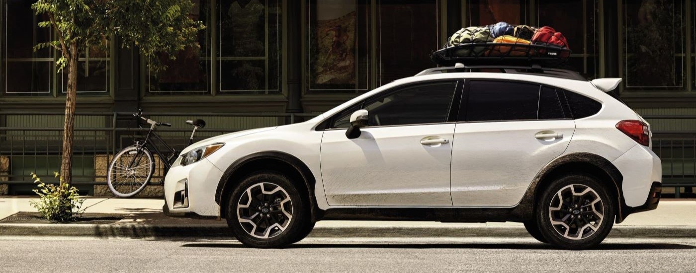 A white 2016 Subaru Crosstrek is shown parked on a city street.