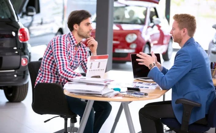 two well dressed men working out a deal at Queensboro Toyota