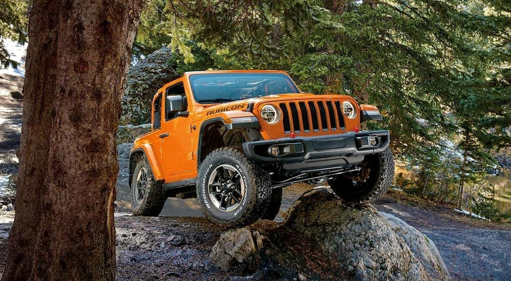 An orange 2019 Jeep Wrangler Rubicon is shown from the front at an angle after leaving a dealer that has a used Jeep for sale.