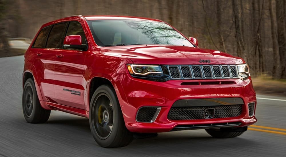 A red 2020 Jeep Grand Cherokee Trackhawk is shown from the front at an angle.