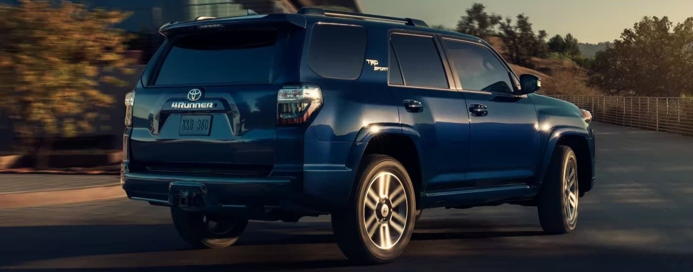A blue 2023 Toyota 4Runner TRD Sport is shown from the rear while driving.
