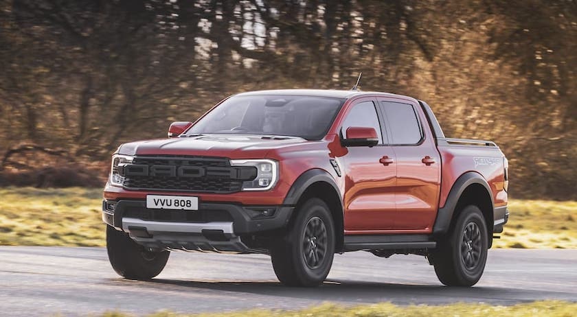 An orange 2024 Ford Ranger Raptor is shown from the front at an angle after leaving a Ford truck dealer.