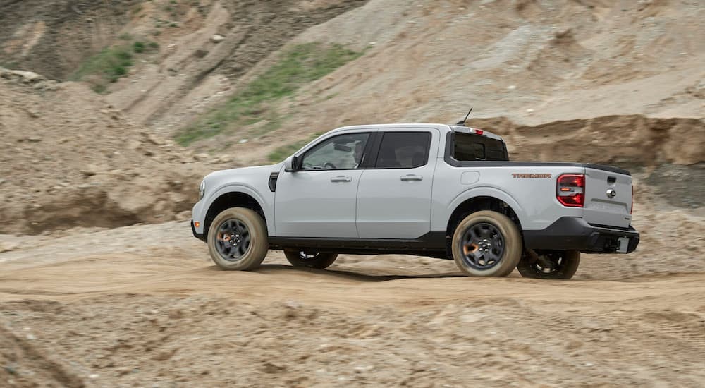 A grey 2023 Ford Maverick Tremor is shown from the side while off-road after leaving a Ford truck dealer.